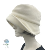 Alice wide from brim cloche hat for women handmade in cream fleece with satin hydrangea brooch in shades of brown Boston Millinery modeled on a hat mannequin plain Side view
