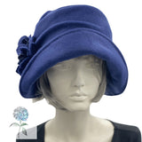 Alice wide from brim cloche hat for women handmade in blue fleece with satin hydrangea brooch in shades of brown Boston Millinery modeled on a hat mannequin frontview