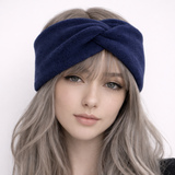 Woman wearing a navy blue headband with long, wavy hair on a white background