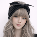 Woman wearing a black headband with a bow on a white background