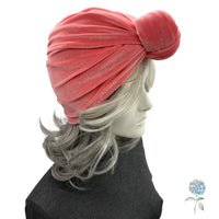 Coral turban on a mannequin head with gray hair against a white background