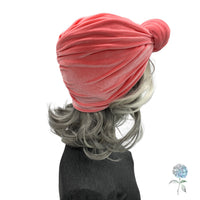 Coral color velvet knot turban shown on mannequin side view