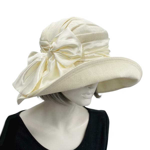Wide brim linen derby hat handmade in cream linen shown modeled on a hat mannequin, wide brim drama and elegance front view Boston Milliner