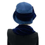 Blue velvet 1920s style cloche hat with velvet bow modeled on a hat mannequin rear view