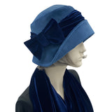 Blue velvet 1920s style cloche hat with velvet bow modeled on a hat mannequin side view