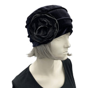 Velvet Cloche Hat and Chemo Headwear in black with Satin Flower Embellishment modeled on a hat mannequin side view with flower