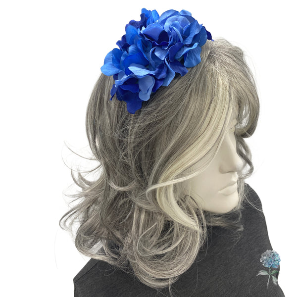 Mannequin head with gray hair and a blue floral headband on a white background