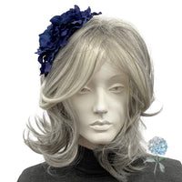 Mannequin head with gray hair and a blue flower headband on a white background