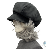 Black cap on a mannequin with a gray and white wig against a white background
