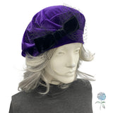 Purple velvet turban with a bow on a mannequin head against a white background