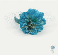 Blue flower hair clip with decorative elements on a white background