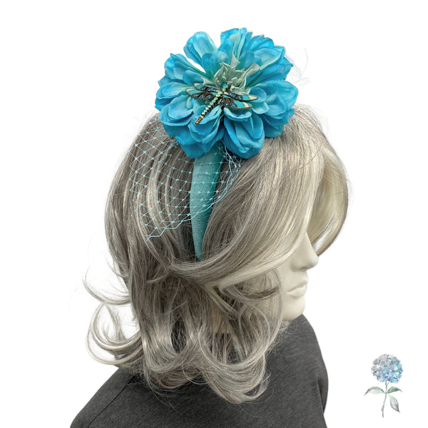 Blue floral hair accessory with a dragonfly on a mannequin head with gray hair.