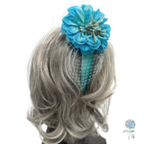 Blue floral hair accessory with netting on a wig against a white background