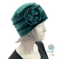 Velvet Cloche Hat and Chemo Headwear in Green with Satin Flower Embellishment modeled on a hat mannequin side view with flower