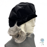 Black hat on a mannequin head with blonde hair against a white background
