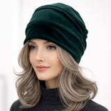 Woman wearing a dark green beanie on a white background