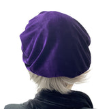 Purple beret handmade in soft velvet. Satin lined hat shown on a mannequin head. Rear view. Boston Millinery
