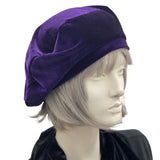 Purple beret handmade in soft velvet. Satin lined hat shown on a mannequin head.Side view. Boston Millinery