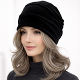 Woman wearing a black beanie with a plain background