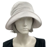 Alice Cloche hat for women handmade in white linen front view. Modeled on a hat mannequin. Boston Millinery 