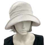 Alice Cloche hat for women handmade in white linen top front view. Modeled on a hat mannequin. Boston Millinery 