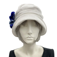 Alice cloche narrow brim hat  hat in antique white linen with blues hydrangea petal brooch front view