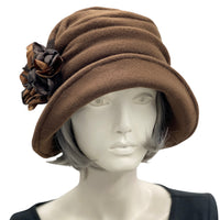 Alice wide from brim cloche hat for women handmade in brown fleece with satin hydrangea brooch in shades of brown Boston Millinery  modeled on a hat mannequin  front view