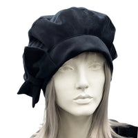 Black velvet beret with bow modelled on a mannequin front view 