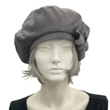 Gray velvet beret with bow modelled on a mannequin front view 