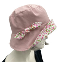 Betty cloche hat in dusky pink linen with pink cotton floral brim and bow  side view