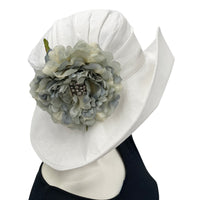 White Linen derby hat for women with gray peony style brooch modeled on a hat mannequin Boston Millinery USA