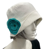 Linen 1920s Cloche Hats Eleanor style cream linen with teal chiffon rose brooch  modeled on a hat mannequin 