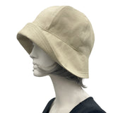 Polly wide front brim beige ,linen cloche hat with ribbon flower and button brooch plain side view