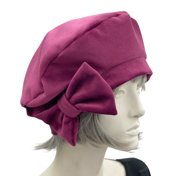 Raspberry velvet beret with bow modelled on a mannequin front view 