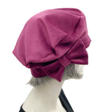 Raspberry velvet beret with bow modelled on a mannequin side view 