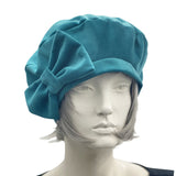 teal velvet beret with bow modelled on a mannequin front view 