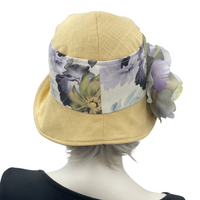 Yellow linen  Eleanor with wide front brim cloche  hat with floral band and large flower brooch rear view  Boston Millinery 