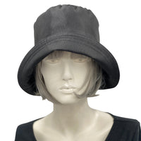Black showerproof rain hat handmade in black polyester and lined in cotton shown modeled on a hat mannequin . Boston Millinery The Eleanor front view