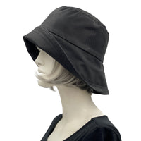 Black showerproof rain hat handmade in black polyester and lined in cotton shown modeled on a hat mannequin . Boston Millinery The Eleanor side view