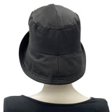 Black showerproof rain hat handmade in black polyester and lined in cotton shown modeled on a hat mannequin . Boston Millinery The Eleanor cloche hat rear view 
