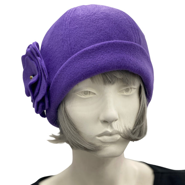 1930s Cloche Hat for Women modeled on a hat mannequin. Handmade in warm Fleece Hat. Purple with Large Flower Brooch, Satin Lined Winter Hat, Handmade in USA Boston Millinery. Front view 