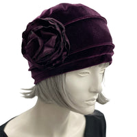 Velvet Cloche Hat and Chemo Headwear in Eggplant with Satin Flower Embellishment modeled on a hat mannequin front side view with flower