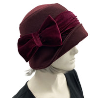 Cloche Hat the Eleanor narrow front brim dark burgundy eggplant wool with velvet band and square bow handmade by Boston Millinery  modeled on a hat stand bow side view 