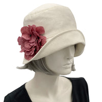 Boston Millinery's handmade Eleanor narrow brim cream linen cloche hat with dusky pink hydrangea brooch modeled on a hat mannequin 