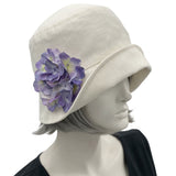 Boston Millinery's handmade Eleanor narrow brim cream linen cloche hat with purple hydrangea brooch modeled on a hat mannequin 