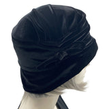 1920s style cloche hat for women in black velvet. Small brim hat with removable bow modeled on a hat mannequin side view  Boston Millinery 