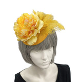 yellow fascinator with yellow peony and feather on mannequin head